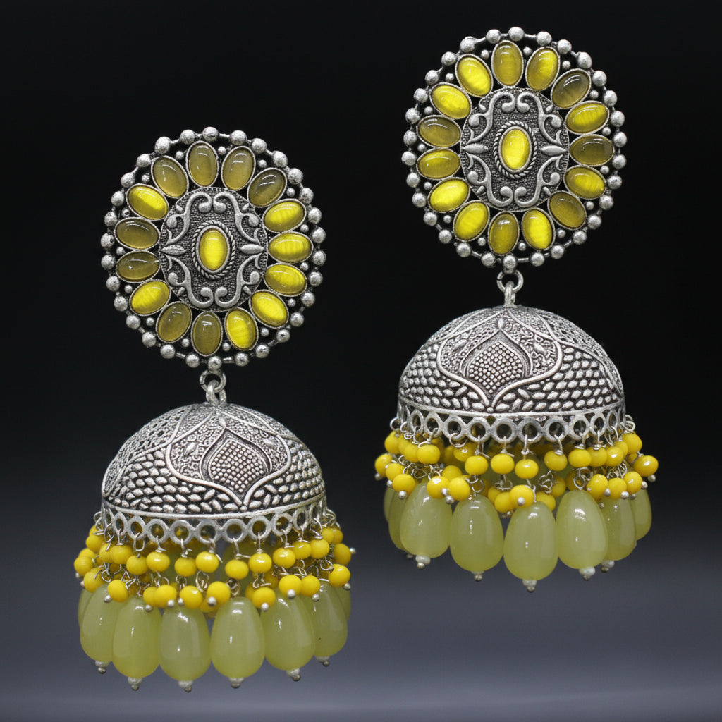 Pair of silver and yellow beaded earrings on a black background