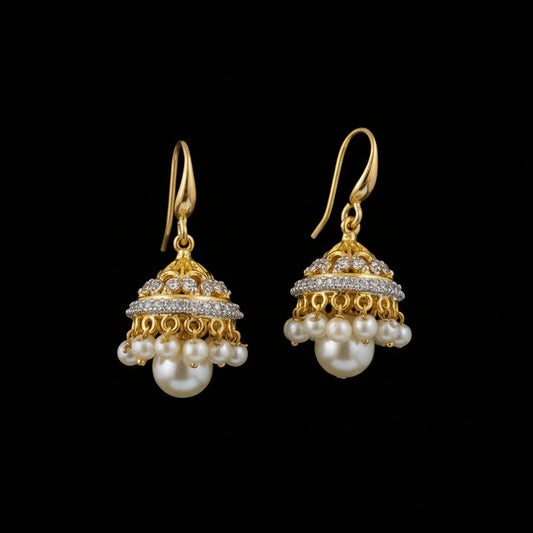 Gold and pearl earrings on a black display stand