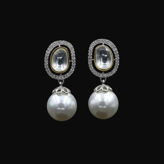 A pair of gold and silver drop earrings with oval clear stone tops and large white pearl drops, displayed on a black stand against a black background with the SAHELL MY BEST FRIEND logo above.