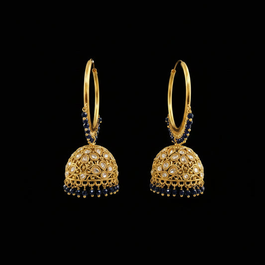 A pair of gold-plated Indian jhumka earrings with navy blue bead accents and clear stone embellishments, displayed on a black stand against a gray background. The brand logo 'SAHELI MY BEST FRIEND' is visible in the top left corner.