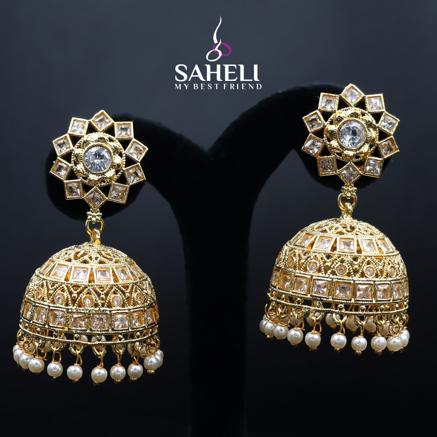 Gold and pearl earrings with 'Saheli' branding on a dark background