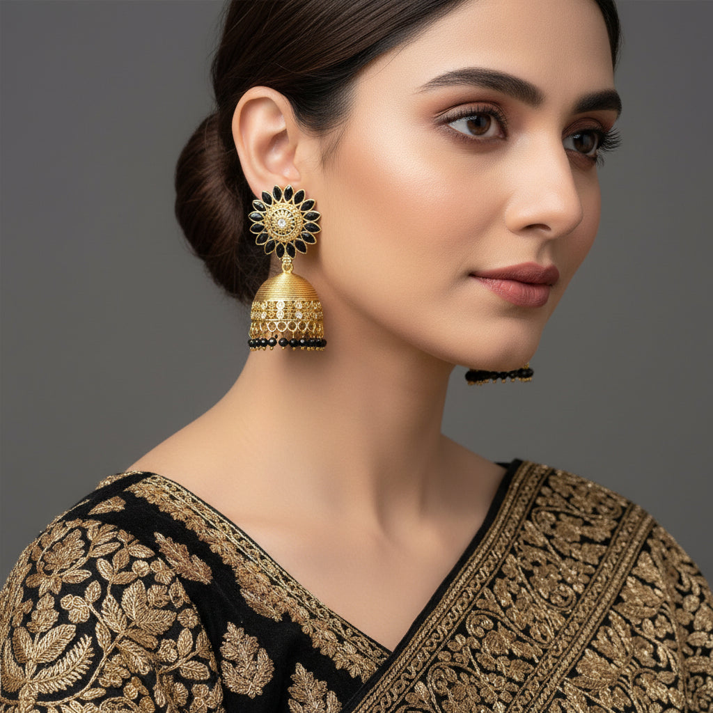 Gold and black earrings with 'Saheli' branding on a dark background