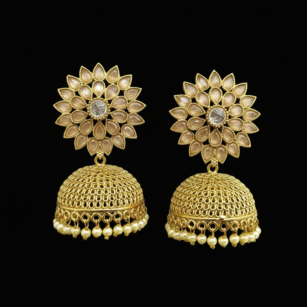 Gold earrings with floral design on a gray stand against a light blue background