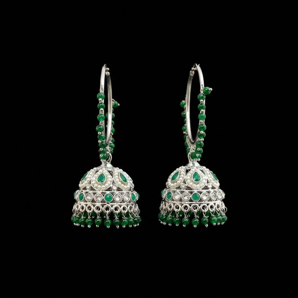 Green and silver earrings on a gray stand with HP logo in the background
