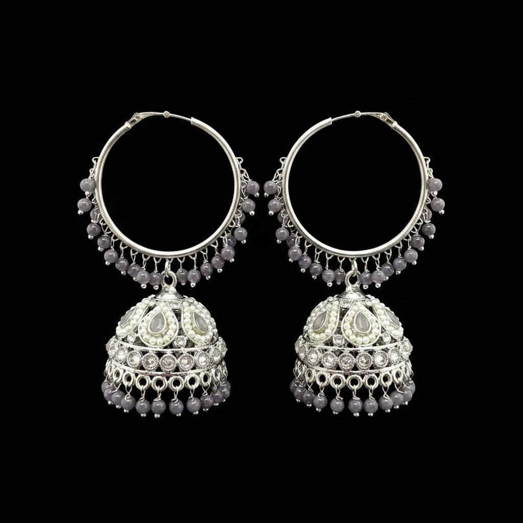 Pair of silver hoop earrings with purple beads on a black stand.