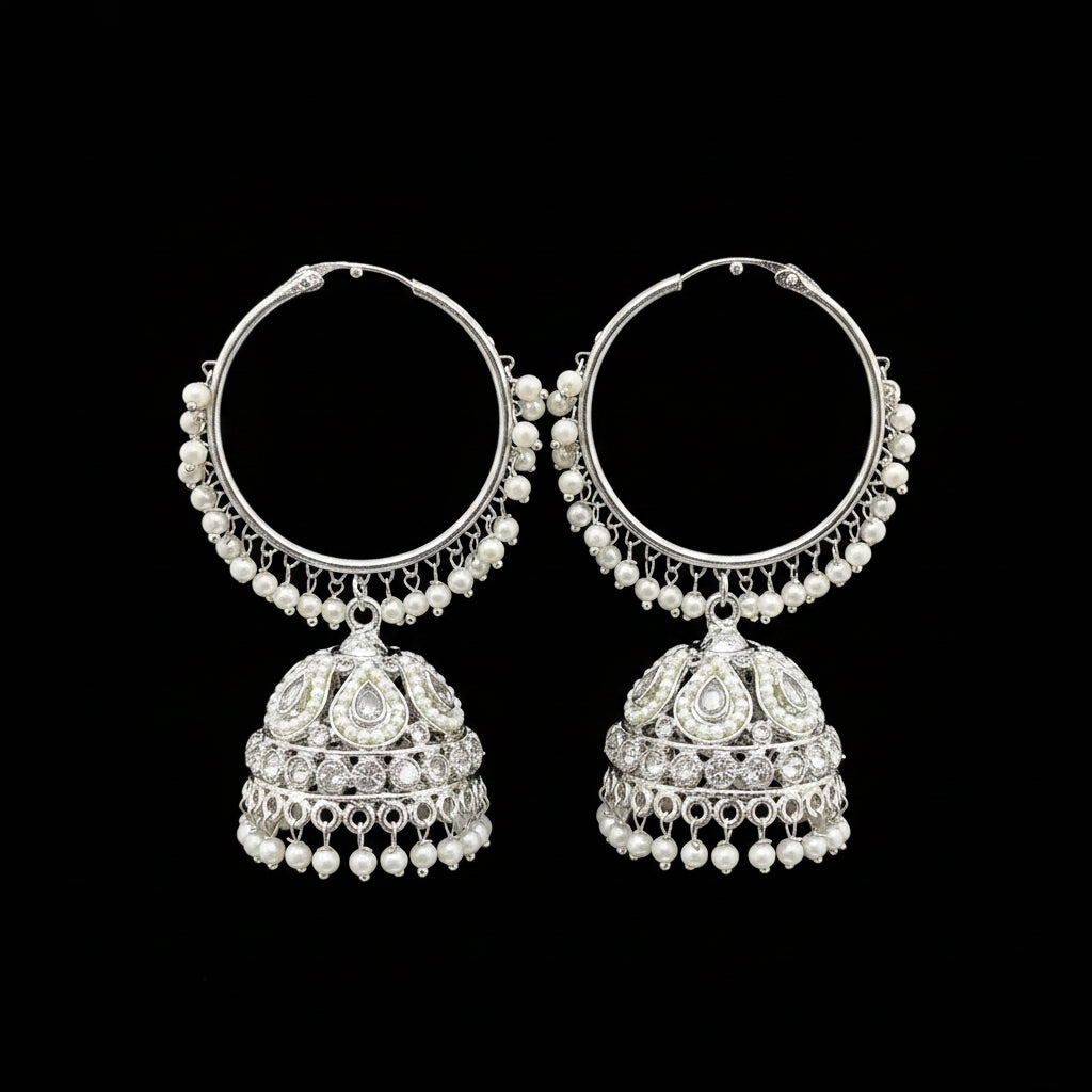 Pair of silver hoop earrings with pearl and gemstone drops on a black stand.