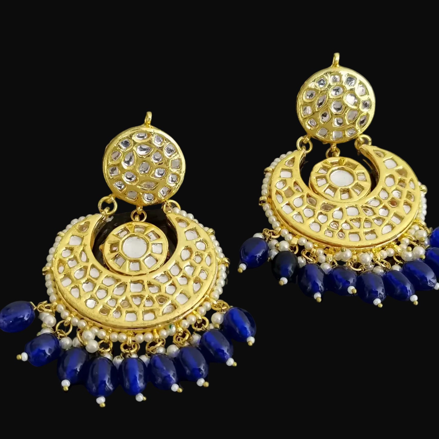 Pair of gold and blue earrings on a black background