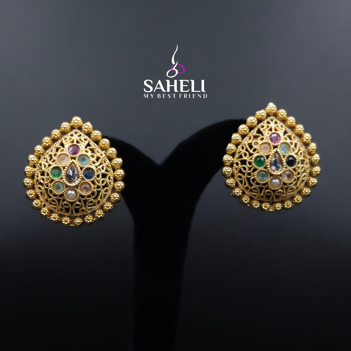 Gold earrings with gemstones on a black background, featuring the brand 'Saheli'.