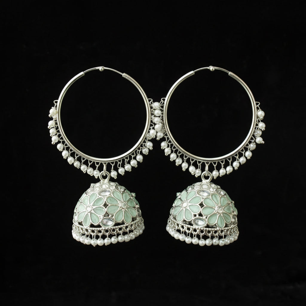 Pair of silver hoop earrings with green gemstones on a black background
