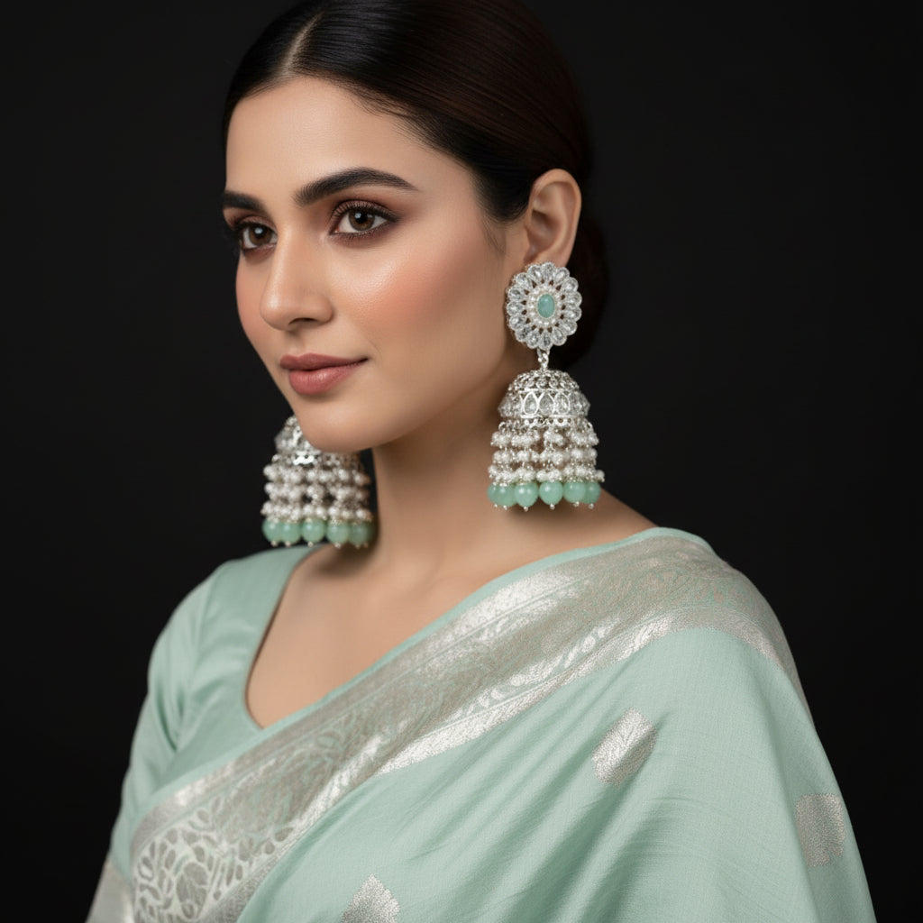 Pair of silver and turquoise earrings with 'Saheli' branding on a black background