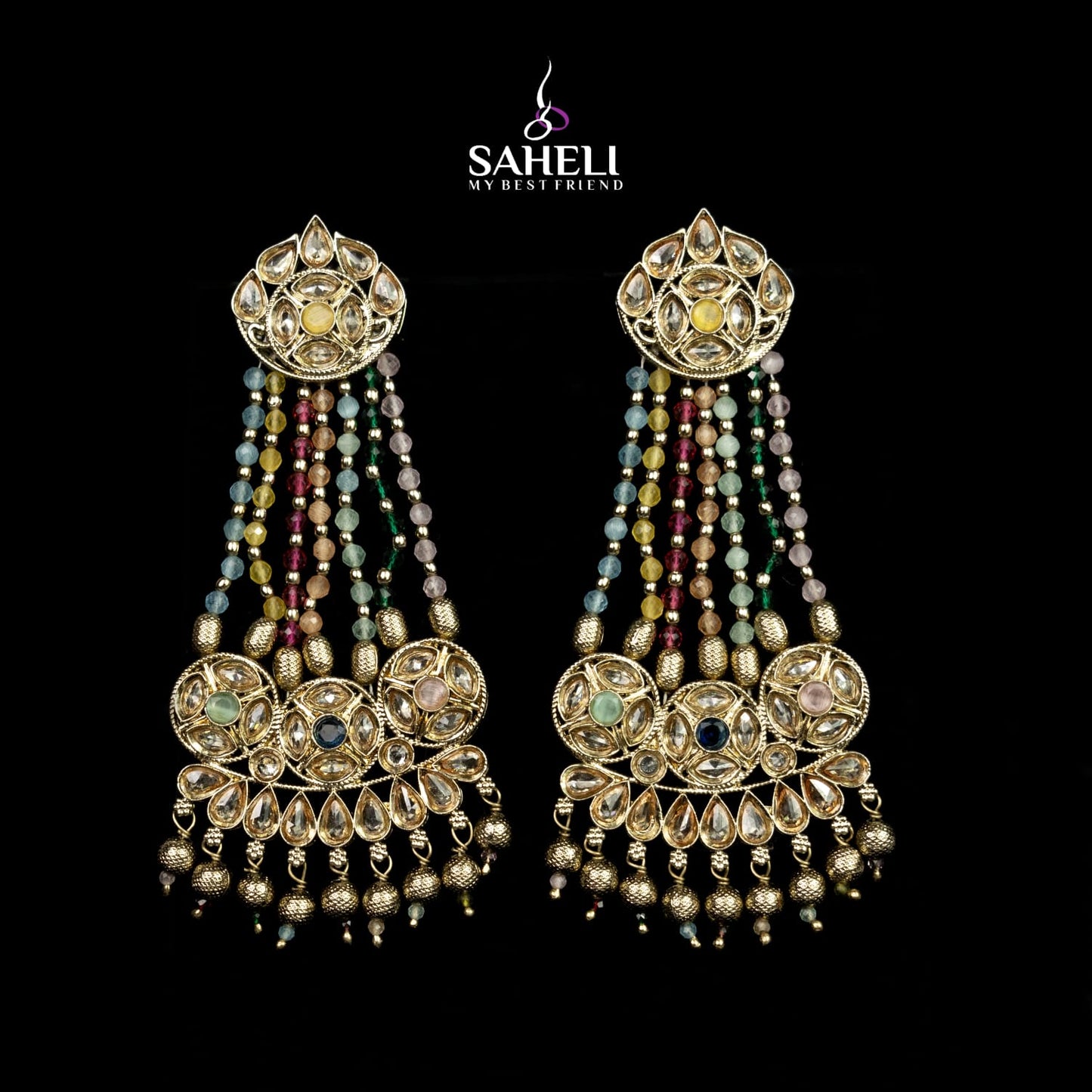 Ornate earrings with beads and gold detailing on a black background, featuring the brand 'Saheli'.