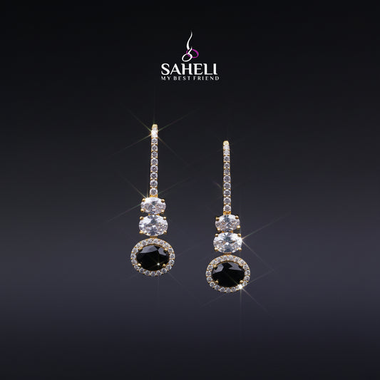 Pair of earrings with black gemstones and clear stones on a dark background, featuring the brand 'Saheli'.