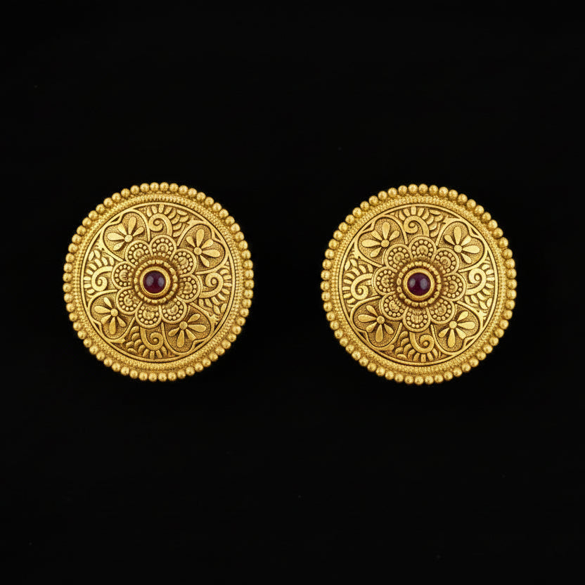Pair of gold earrings with intricate designs on a black background