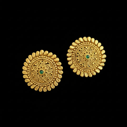 Pair of gold earrings with green gemstones on a gray background