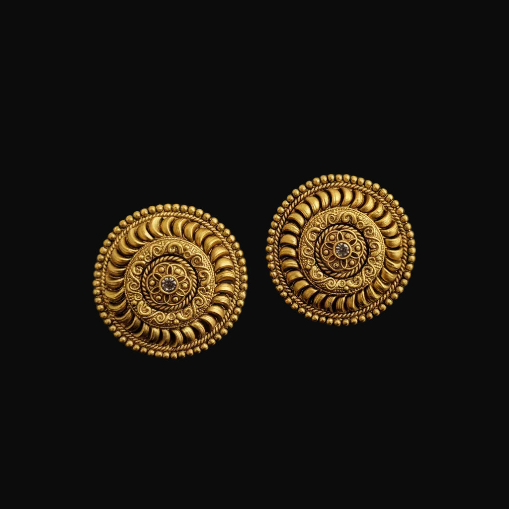 Pair of gold earrings with intricate designs on a black background