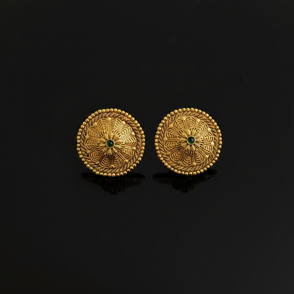 Pair of gold earrings with green gemstones on a black background
