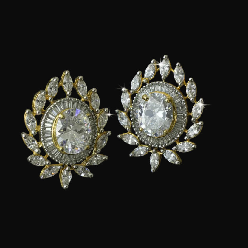 Pair of ornate earrings with clear gemstones on a black background