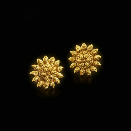 Pair of gold sunflower-shaped earrings on a dark gray background