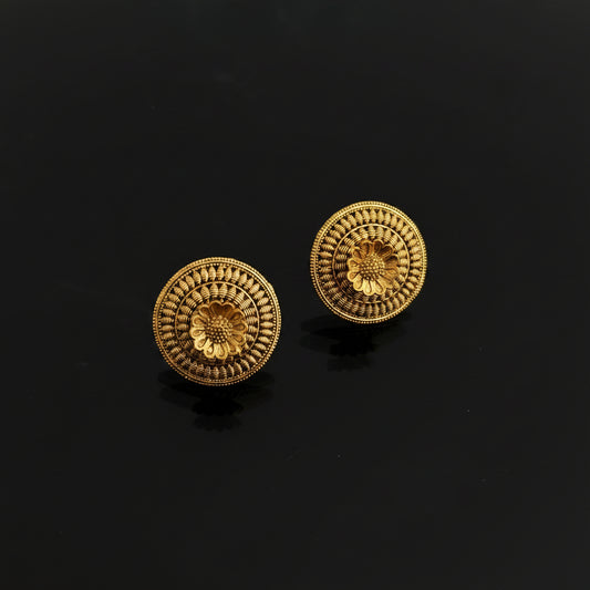 Pair of gold earrings on a dark gray background