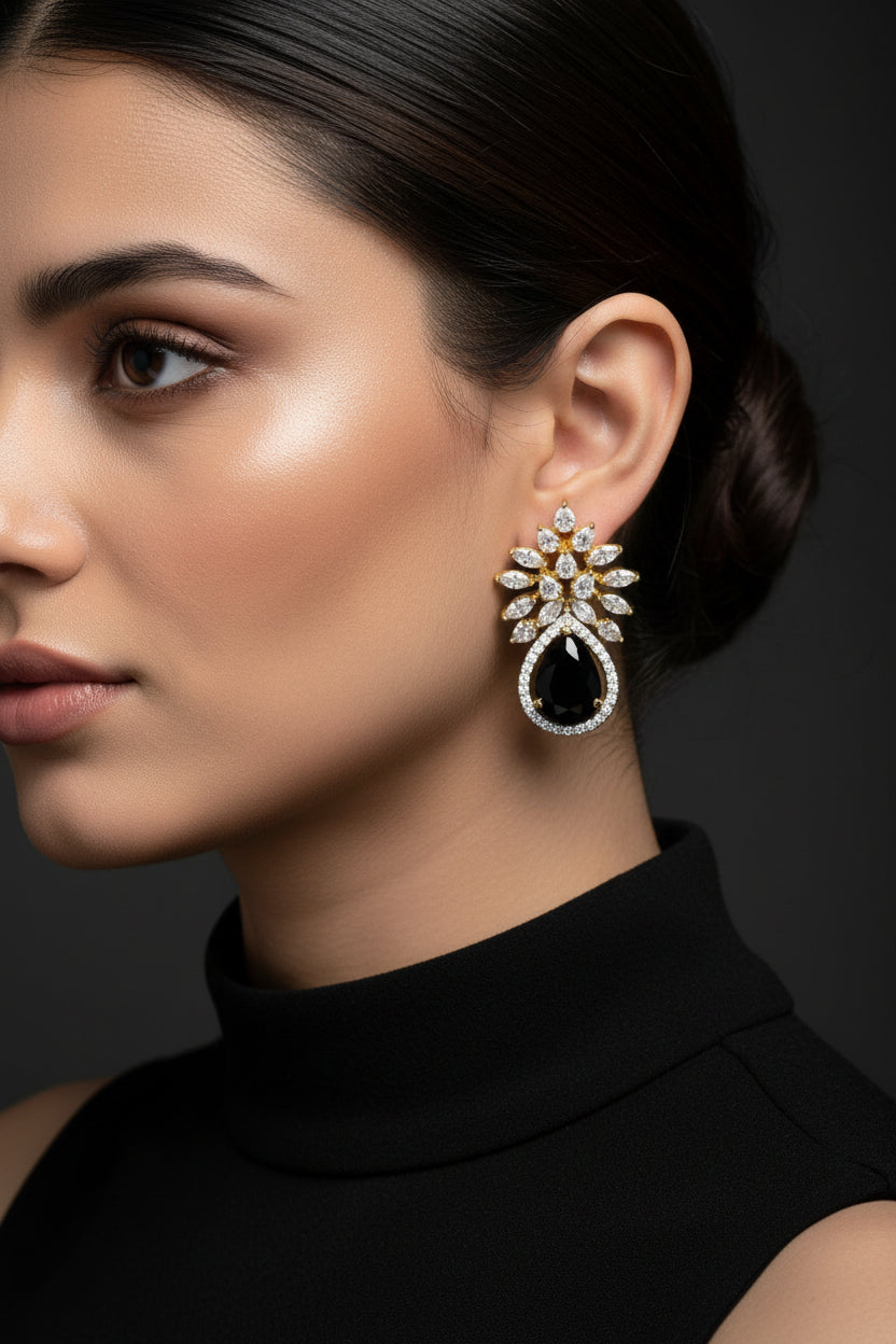 Gold and black earrings on a black background