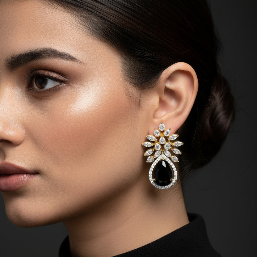 Gold and black earrings on a black background