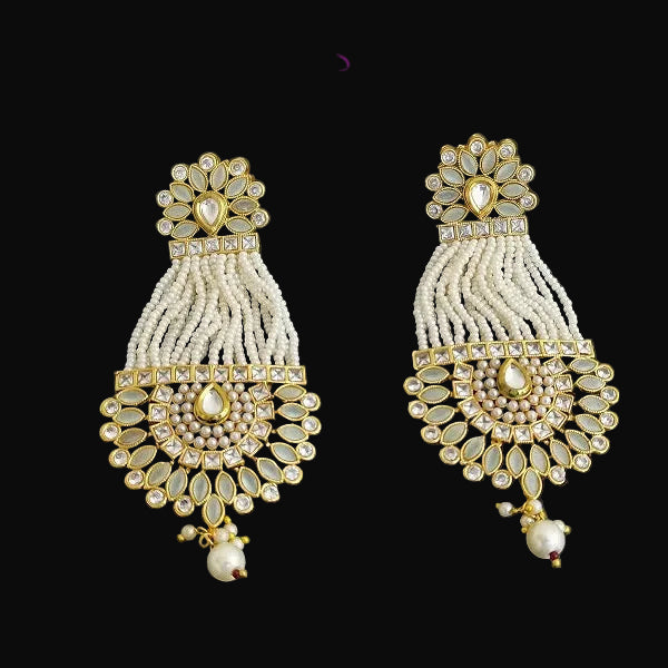Pair of gold and pearl earrings on a dark background with 'SAHELI' branding.
