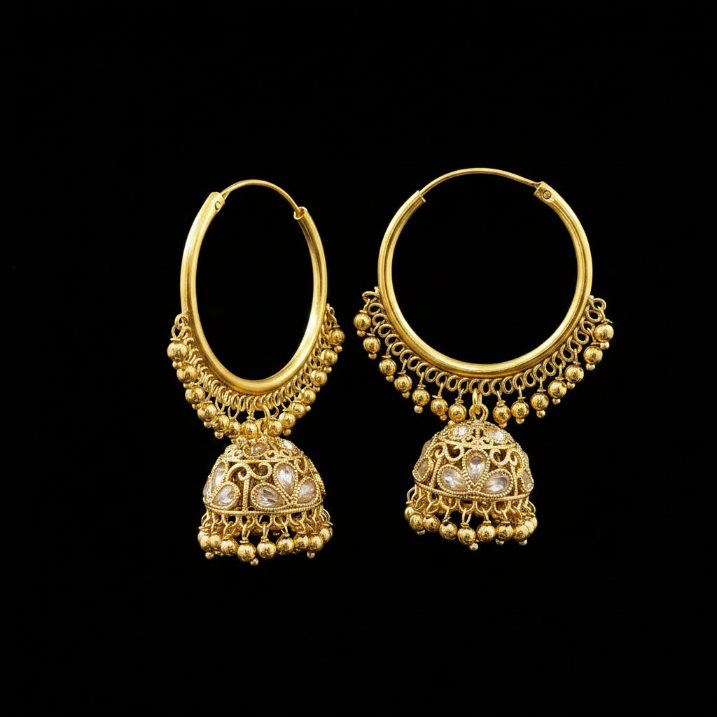 A pair of gold-toned traditional hoop earrings with dangling bell-shaped jhumka charms, displayed on a gray jewelry stand.