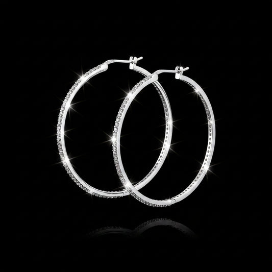 Silver hoop earrings on a gray background with 'Saheli' branding.