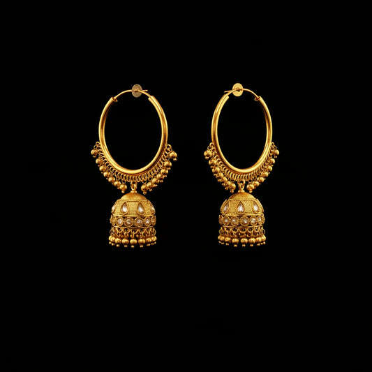 A pair of gold-toned traditional hoop earrings with dangling bell-shaped jhumka charms, displayed on a black jewelry stand against a gray background.
