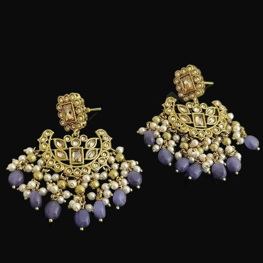 Gold and purple earrings on a dark background
