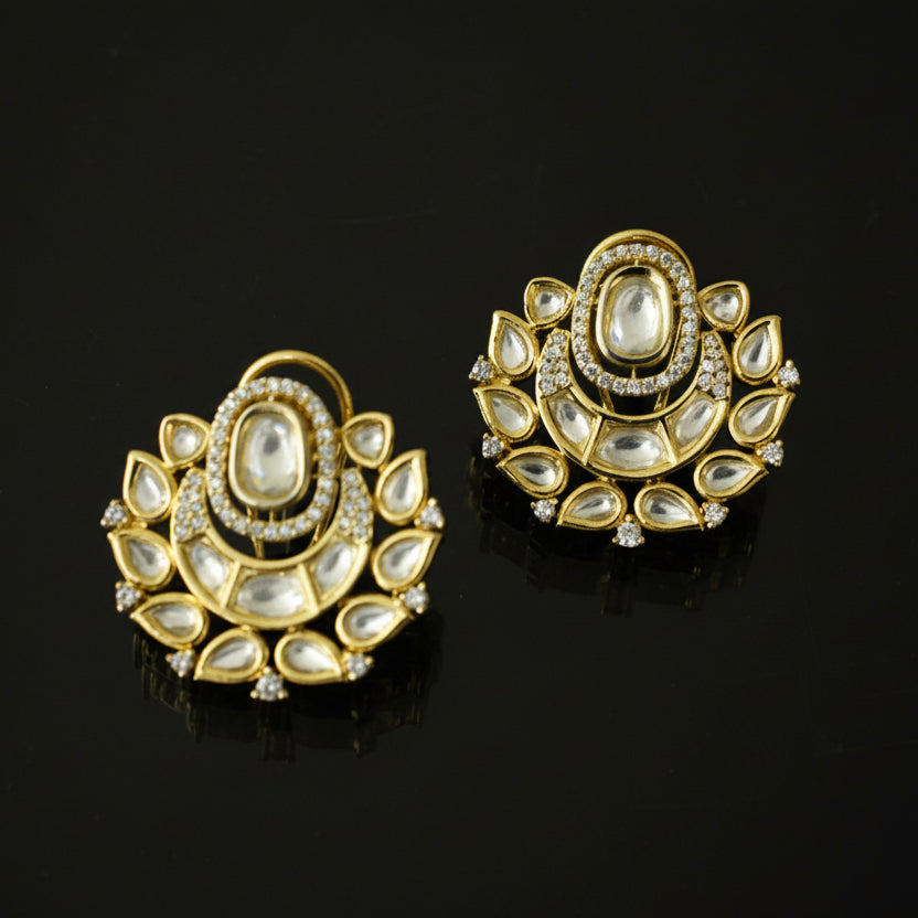Pair of gold and diamond earrings on a black background