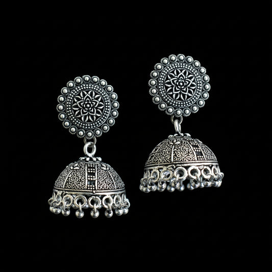 Pair of silver earrings on a decorative background