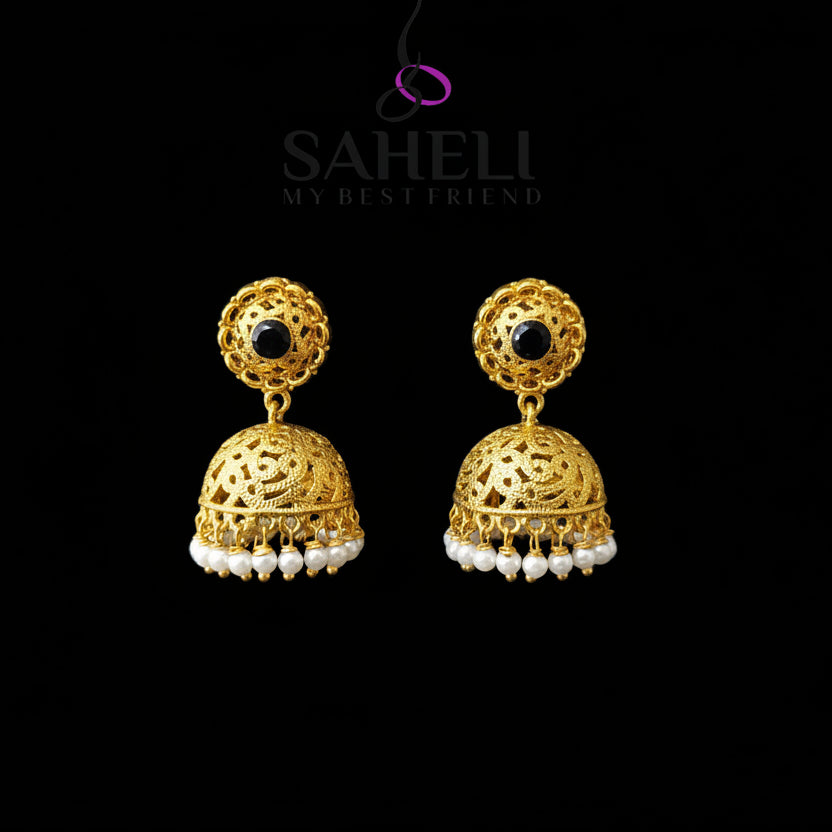 Gold earrings with pearl accents on a gray stand, branded 'Saheli'.