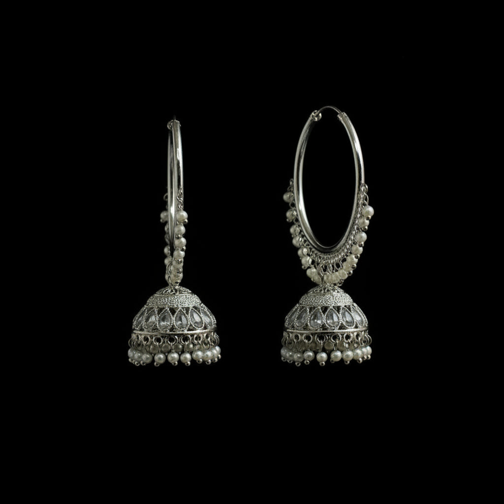 Pair of silver hoop earrings with dangling beads on a black background