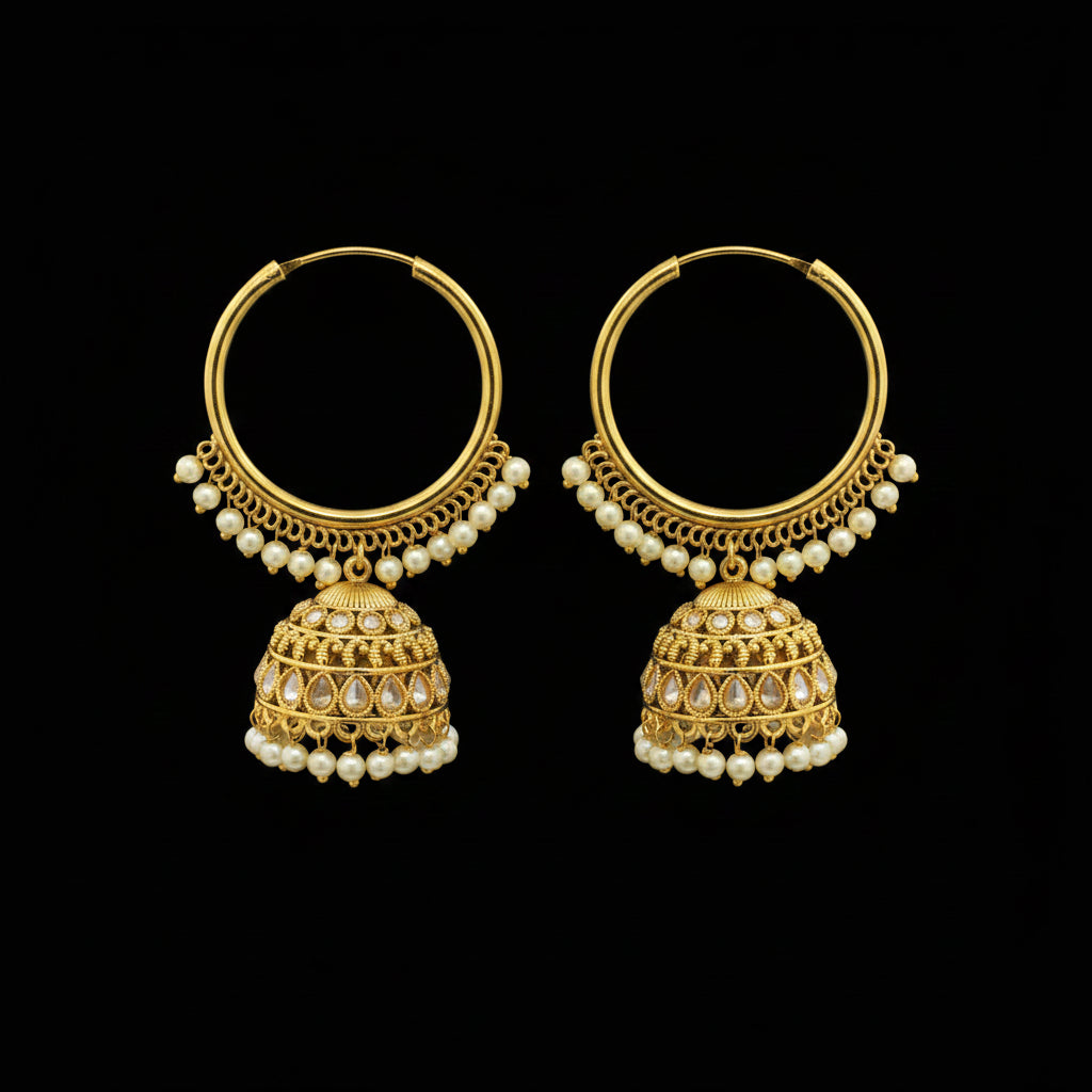 Gold hoop earrings with pearl drops on black earring stands against a gray background.
