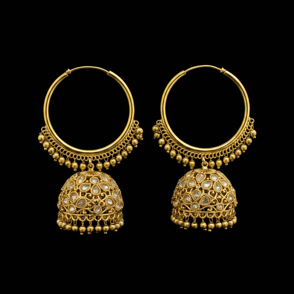 Gold hoop earrings with intricate designs on a black stand against a gray background