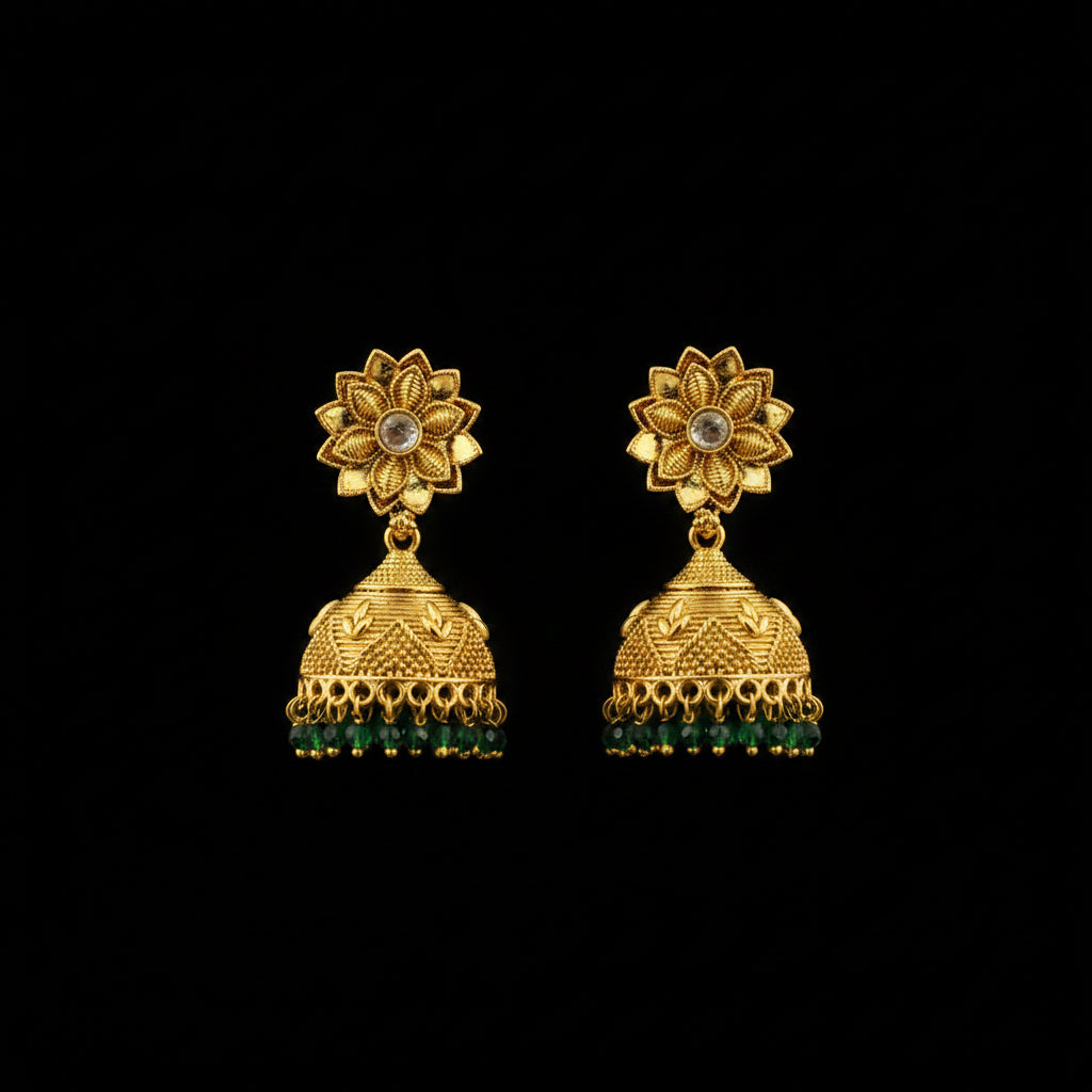 Gold earrings with green accents on a gray stand