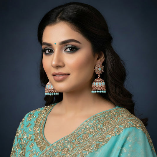 Gold and turquoise earrings on a black stand with a black background