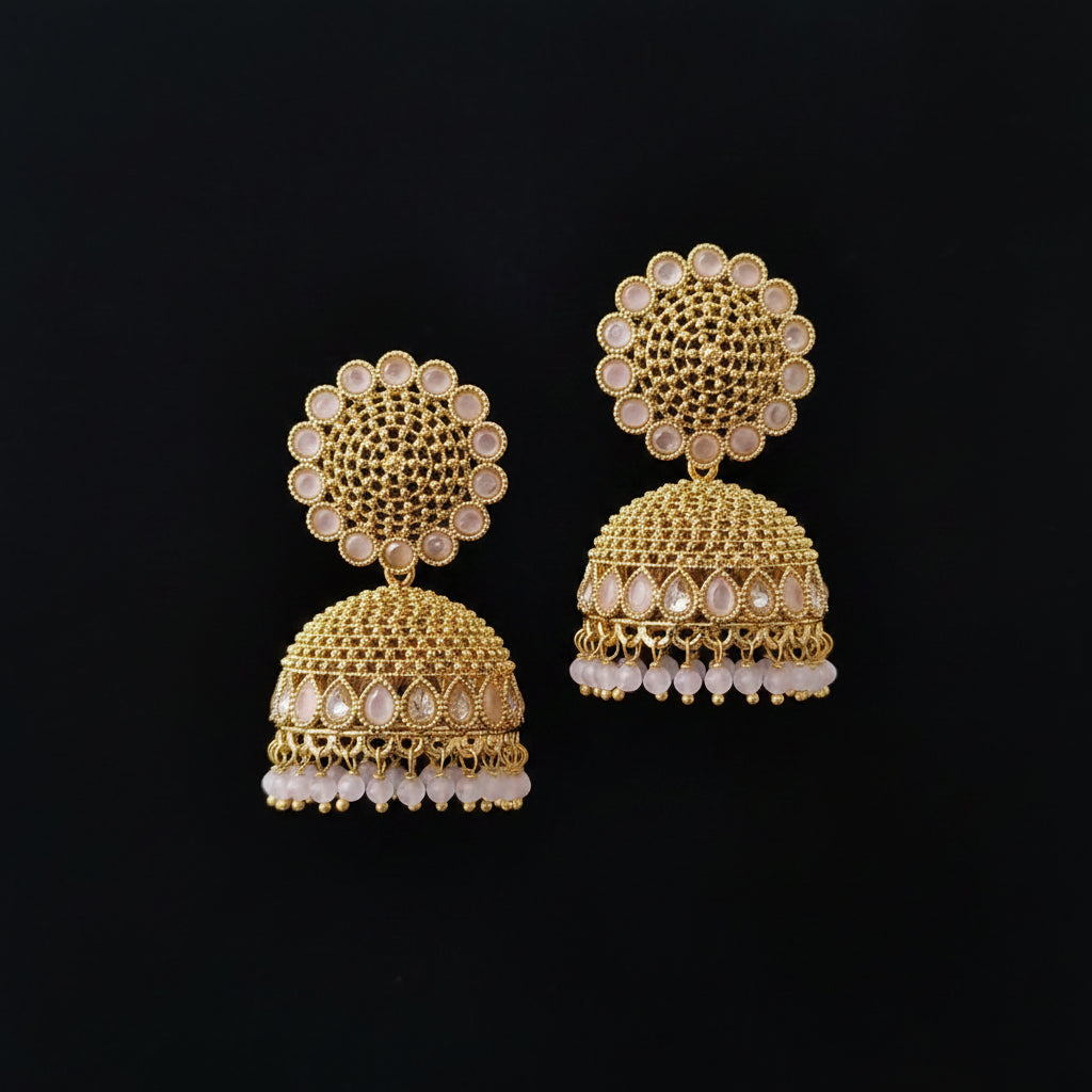 Gold earrings with intricate design on a dark background