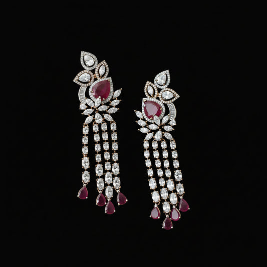 A pair of ornate Indian chandbali earrings featuring large red gemstones and clear stones in a silver-tone setting, displayed on a dark reflective surface. The brand logo 'SAHELI MY BESTFRIEND' is visible in the top left corner.