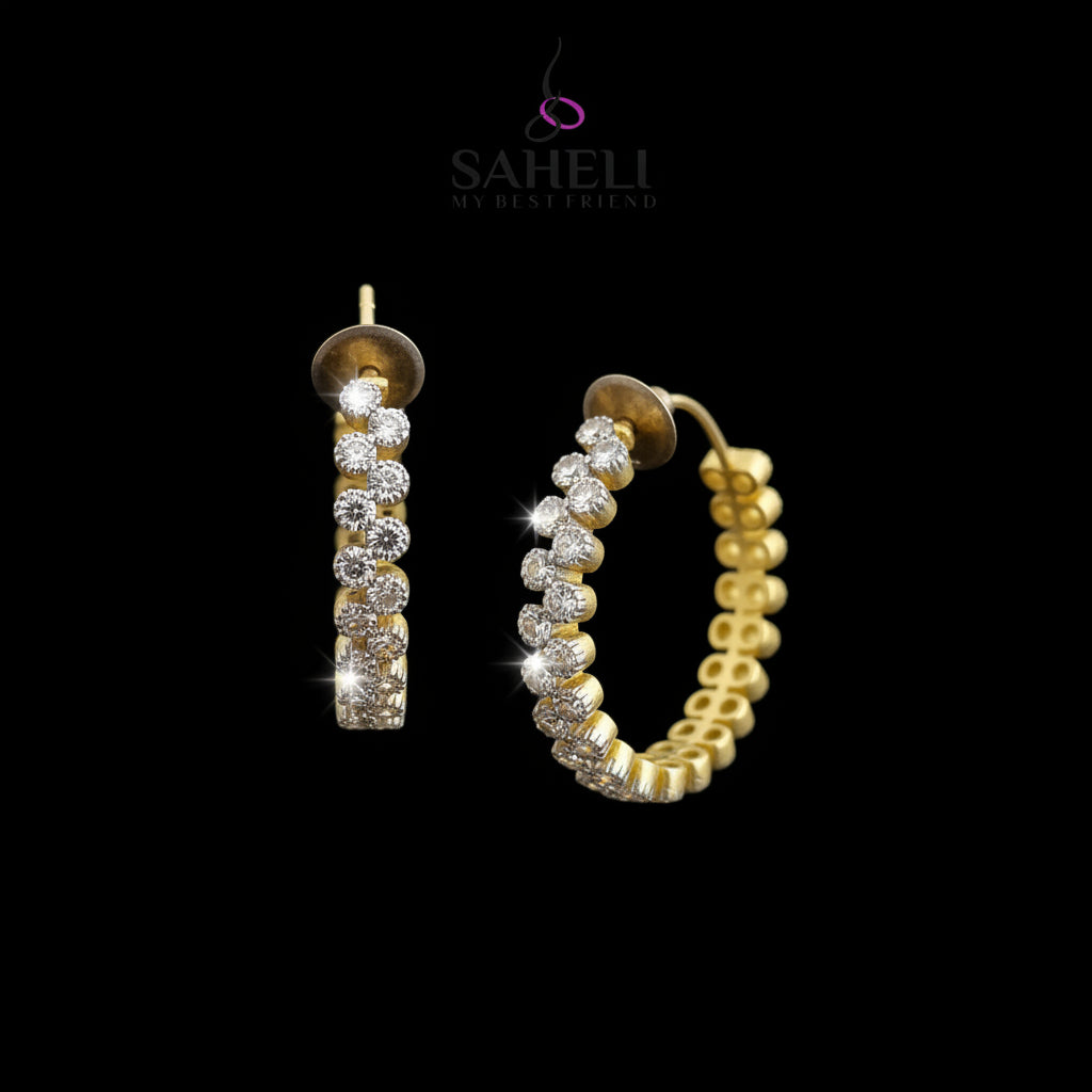 Gold hoop earrings with embedded stones on a gray background, branded 'Saheli'.