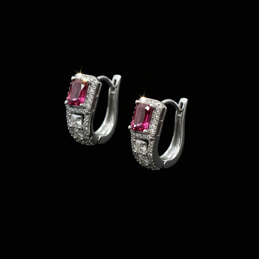 Pair of silver earrings with pink gemstones on a gray background