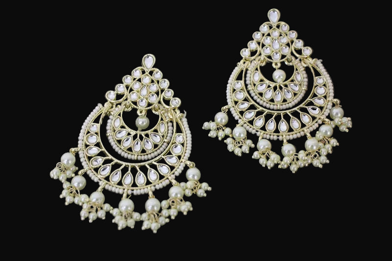 Ornate gold and pearl earrings on a dark background