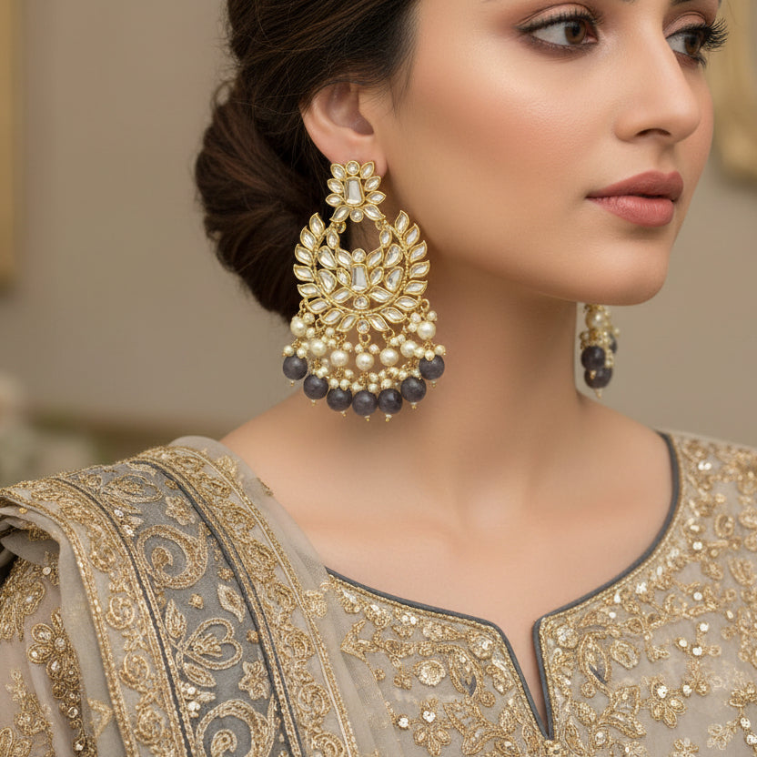 Pair of gold and black earrings on a dark background