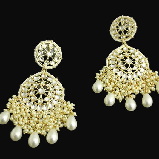 Pair of gold and pearl earrings on a dark background
