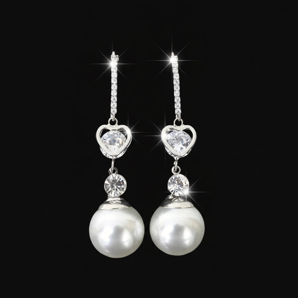 Pearl and crystal drop earrings on a black stand against a dark background