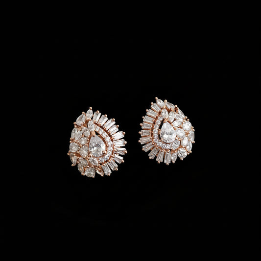 Pair of diamond earrings on a gray background with 'SAHELI' branding.