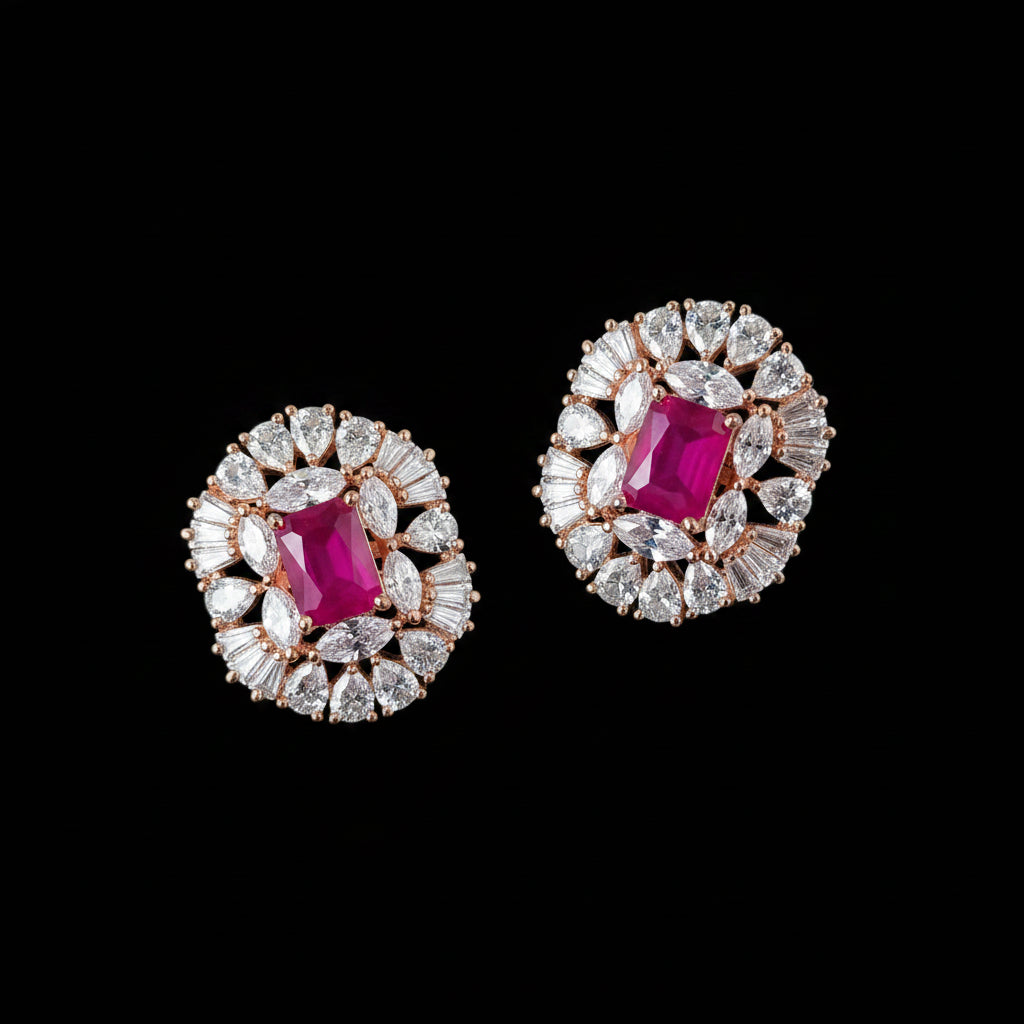 Pair of earrings with pink gemstones and diamond-like stones on a gray background, featuring the brand 'Saheli'.