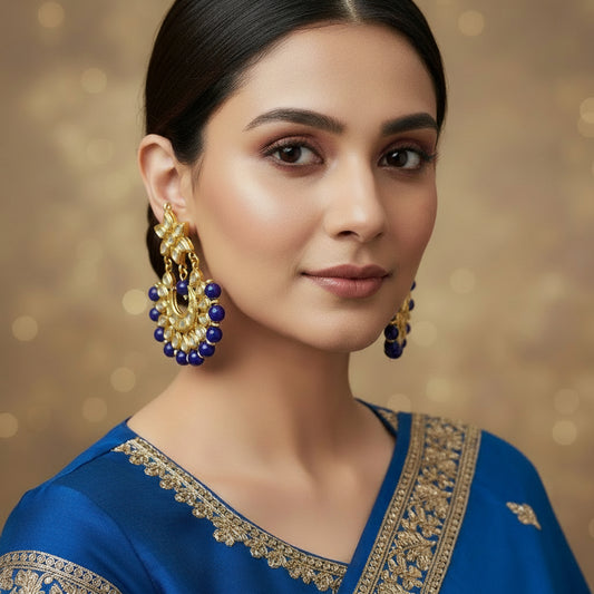 Gold and blue earrings on a dark background with 'SAHELII' branding.