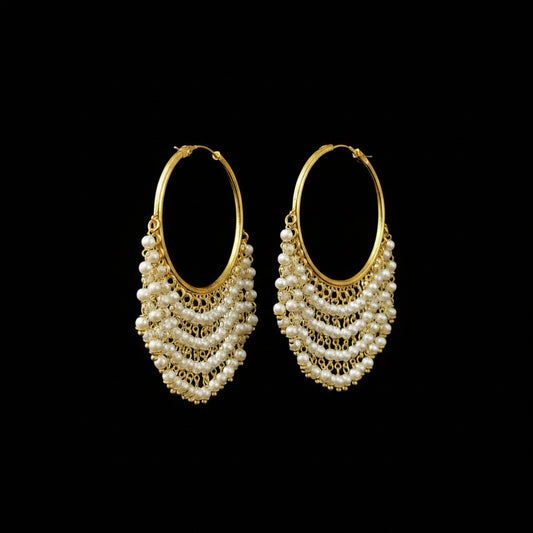 A pair of gold hoop earrings with cascading pearl fringe, displayed on a gray T-stand. The brand logo 'SAHeli MyBest Friend' is visible in the top left corner.